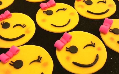Emoji cupcake toppers. Smiley face with pink bow.