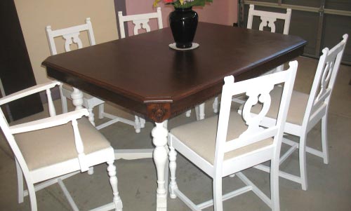 Round Brown Counter Top Plus Black Wooden Legs Also Black Leather Chairs With High Back Placed On The White Rug.